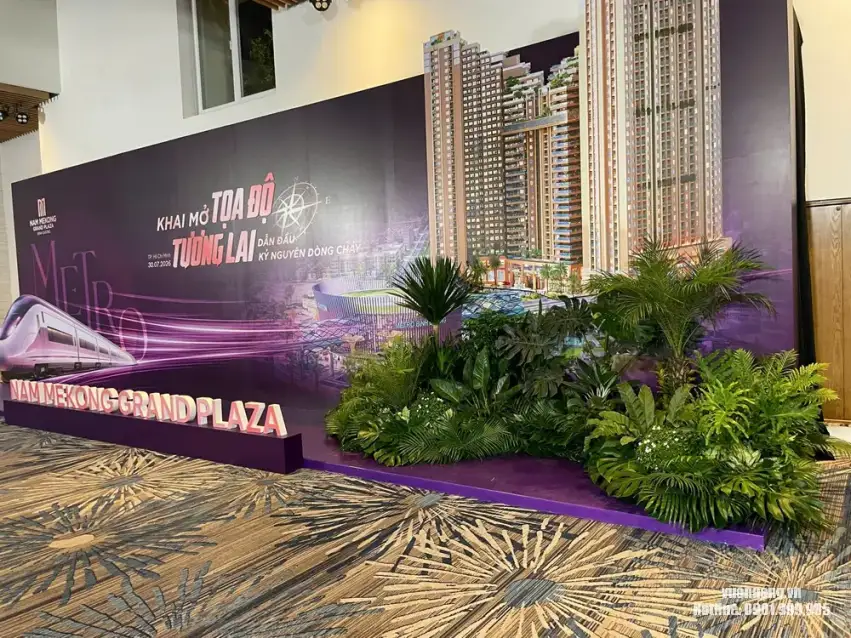 Tiểu cảnh cây sự kiện Nam Mekong Grand Plaza hoàn thiện tại GEM Center Quận 1 Hình ảnh thể hiện tổng thể khu vực sân khấu sau khi Vườn Nắng hoàn thành bố trí gần 100 cây. Mảng xanh được phân tầng để cân bằng với kích thước lớn của backdrop sự kiện.