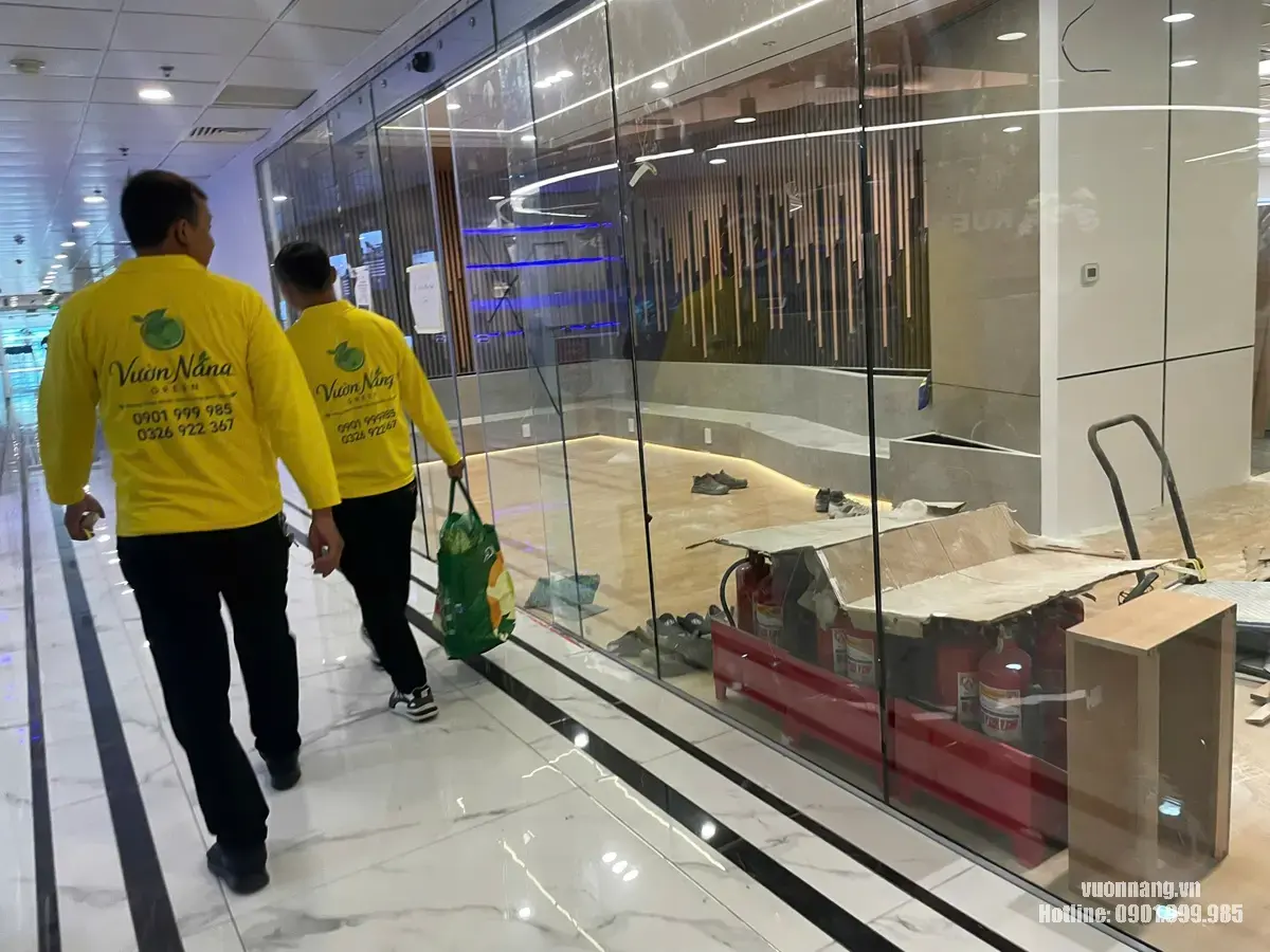 Nhân viên Vườn Nắng chuẩn bị setup cây văn phòng MIK Group tại Vincom Center Quận 1. Đội ngũ Vườn Nắng di chuyển trong tòa nhà để chuẩn bị triển khai bố trí cây tại các khu vực văn phòng.